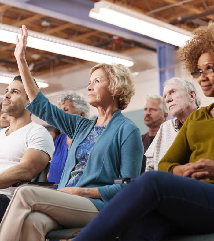 A elderly women raising her hand up